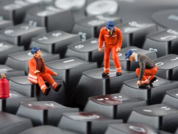 Små figurer i skyddskläder på tangentbord